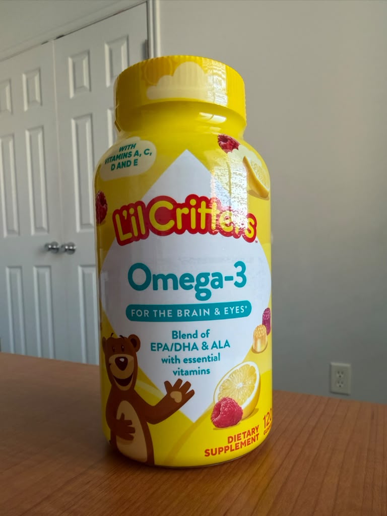 Suplemento infantil Lil Critters Omega-3 con delicioso sabor a frutas y limón, formulado con una mezcla de EPA, DHA y ALA para contribuir al desarrollo del cerebro y la salud visual. Enriquecido con vitaminas A, C, D y E, ideal para complementar la alimentación diaria de los niños. Presentación de 1