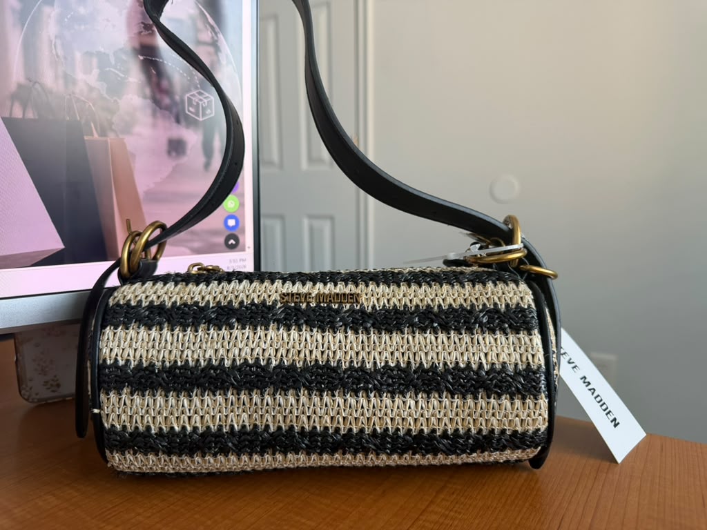 Steve Madden. Cartera de hombro tejida en tonos negro y beige, cierre superior, correa ajustable, detalles en material sintético y logo metálico frontal.